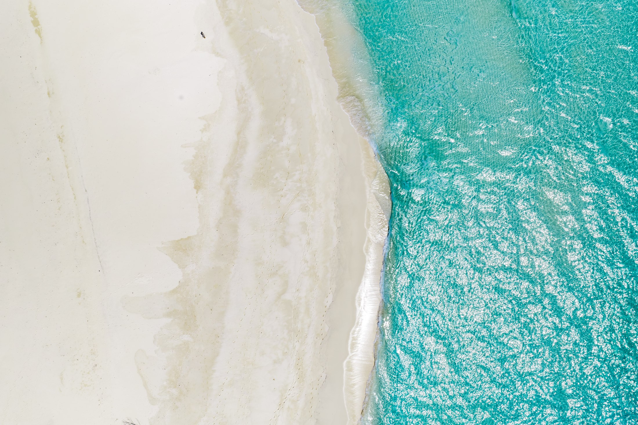 Aerial view of white sand and turquoise water