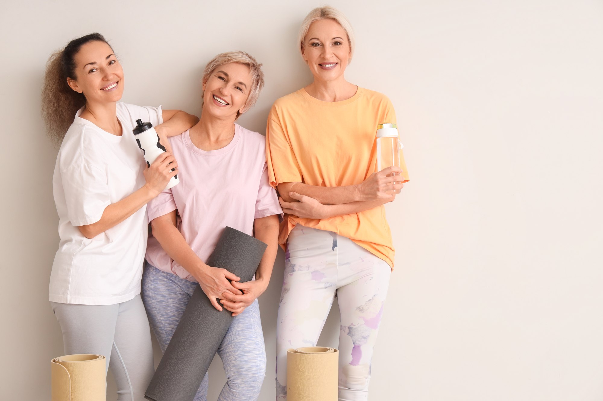 Stock placeholder: women together with exercise mats